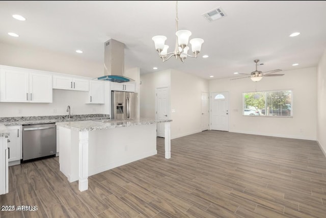 kitchen with white cabinetry, island range hood, stainless steel appliances, a center island, and visible vents
