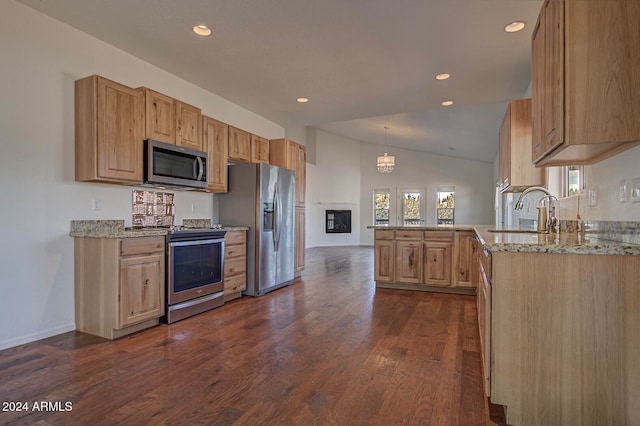 kitchen featuring vaulted ceiling, sink, hanging light fixtures, kitchen peninsula, and stainless steel appliances