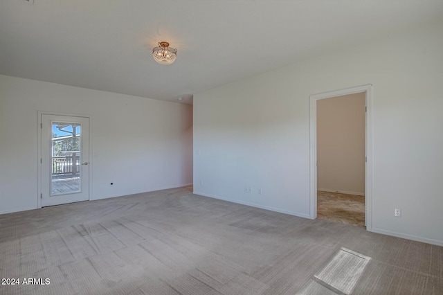 spare room featuring light carpet