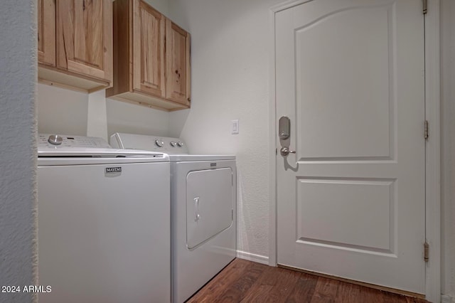 clothes washing area featuring cabinets, separate washer and dryer, and dark wood-type flooring