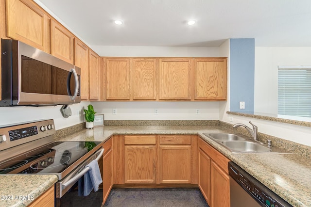 kitchen with light stone counters, sink, and appliances with stainless steel finishes