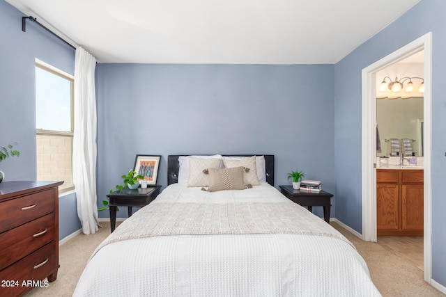 bedroom featuring light carpet and ensuite bath