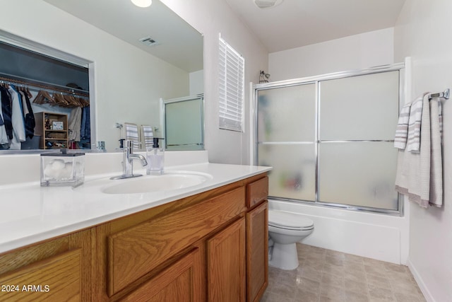 full bathroom featuring vanity, toilet, and enclosed tub / shower combo