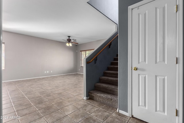 staircase featuring ceiling fan and tile patterned flooring