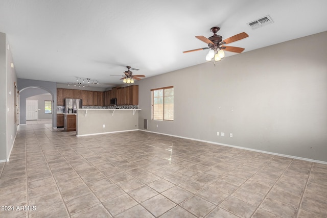 unfurnished living room featuring track lighting, light tile patterned floors, and ceiling fan