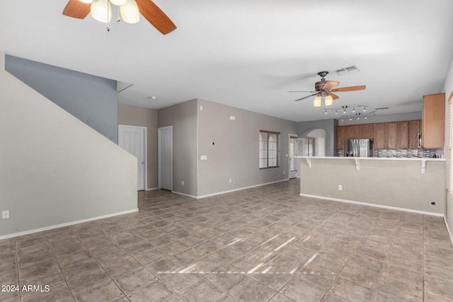 unfurnished living room with ceiling fan, track lighting, and light tile patterned floors