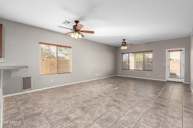 unfurnished room featuring ceiling fan, plenty of natural light, and light tile patterned flooring