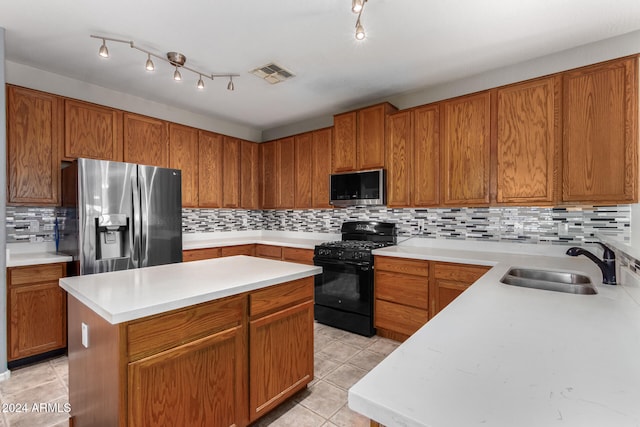 kitchen with appliances with stainless steel finishes, a kitchen island, decorative backsplash, and sink