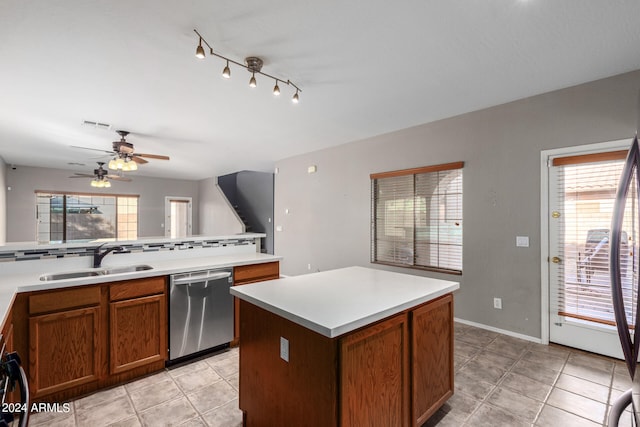 kitchen with a kitchen island, plenty of natural light, sink, and stainless steel dishwasher