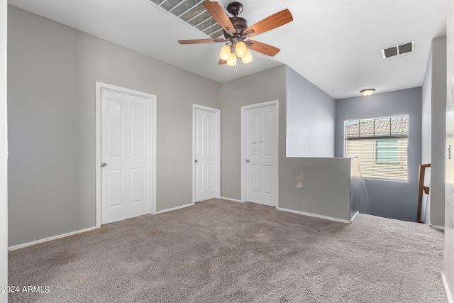 unfurnished bedroom with ceiling fan, two closets, and carpet