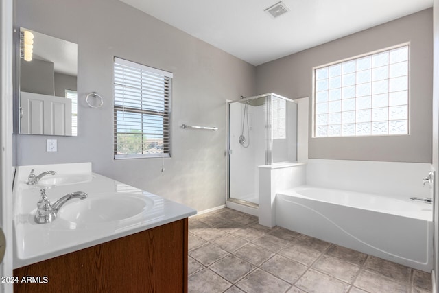 bathroom featuring plus walk in shower, vanity, and a wealth of natural light