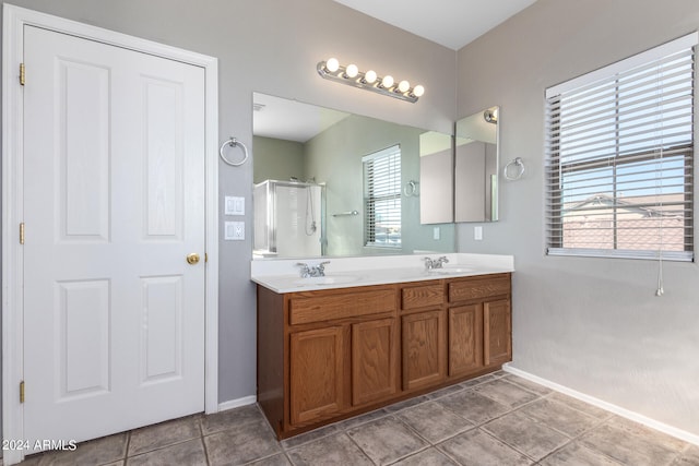 bathroom with tile patterned flooring, a shower with shower door, and vanity