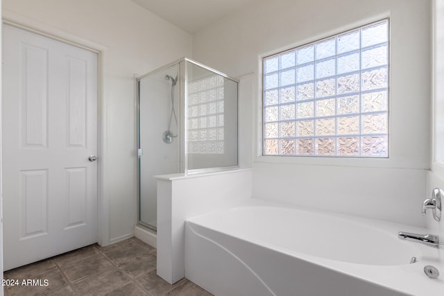 bathroom with tile patterned flooring and shower with separate bathtub