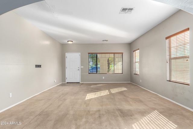 empty room with light colored carpet and a wealth of natural light