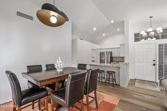 dining room featuring high vaulted ceiling and an inviting chandelier