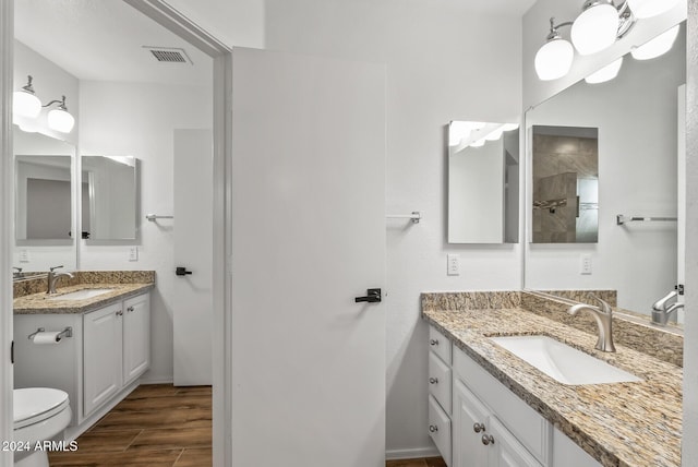 bathroom with hardwood / wood-style floors, vanity, and toilet