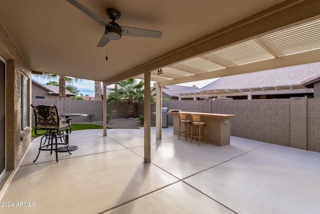 view of patio with a pergola, grilling area, ceiling fan, and an outdoor bar