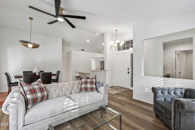 living room featuring ceiling fan with notable chandelier, lofted ceiling, and dark wood-type flooring