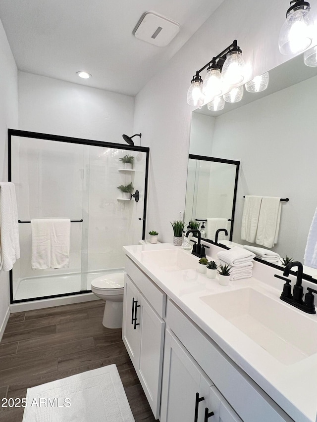 bathroom featuring toilet, hardwood / wood-style floors, walk in shower, and vanity