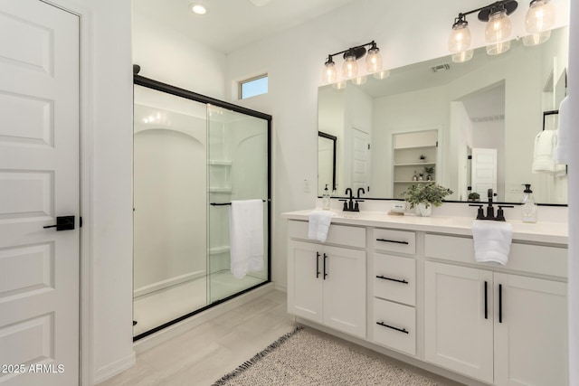 bathroom featuring an enclosed shower and vanity