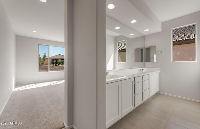 bathroom featuring double vanity, baseboards, a sink, and recessed lighting