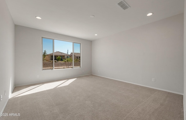 unfurnished room with carpet, visible vents, baseboards, and recessed lighting