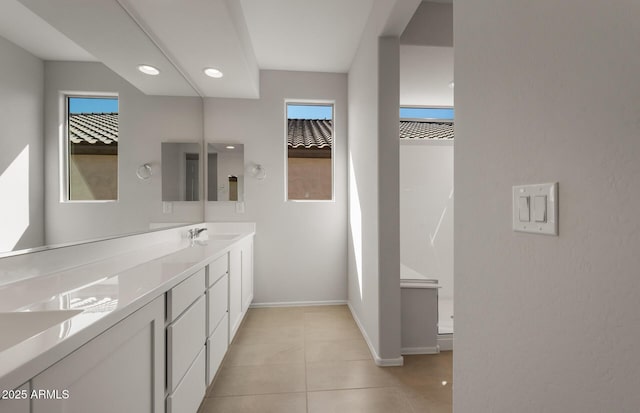 full bathroom featuring tile patterned floors, a sink, baseboards, and double vanity