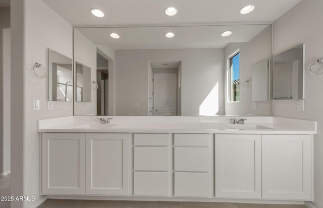 bathroom featuring double vanity, a sink, and recessed lighting