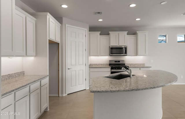 kitchen featuring light tile patterned flooring, a sink, visible vents, white cabinetry, and appliances with stainless steel finishes