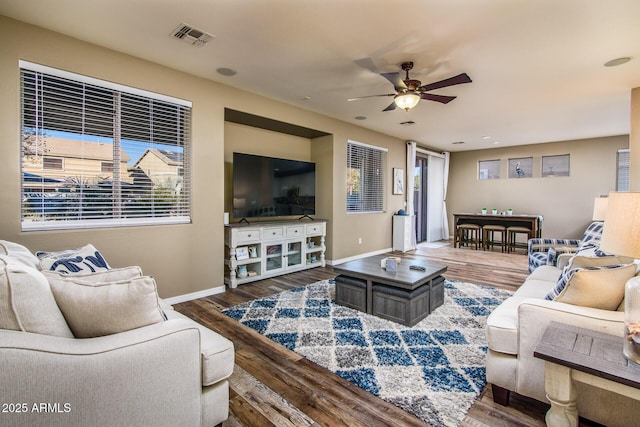 living room featuring ceiling fan and dark hardwood / wood-style flooring