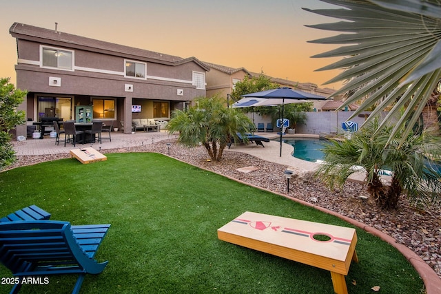 yard at dusk with a fenced in pool and a patio