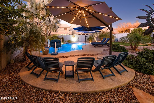 pool at dusk featuring a patio area