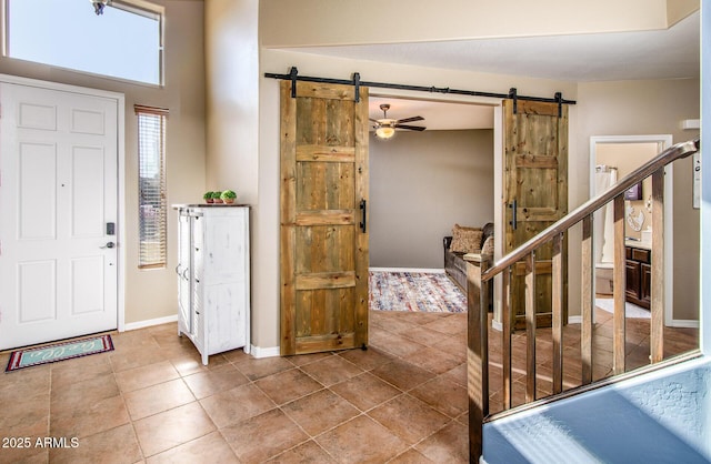 entrance foyer with a barn door and ceiling fan