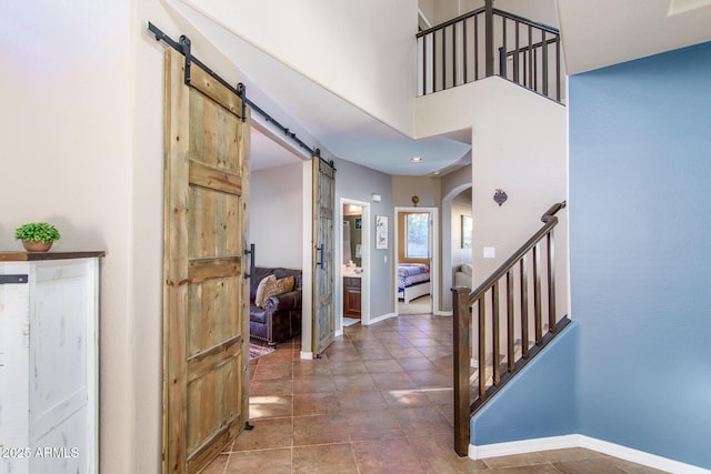 entrance foyer with a barn door and a towering ceiling