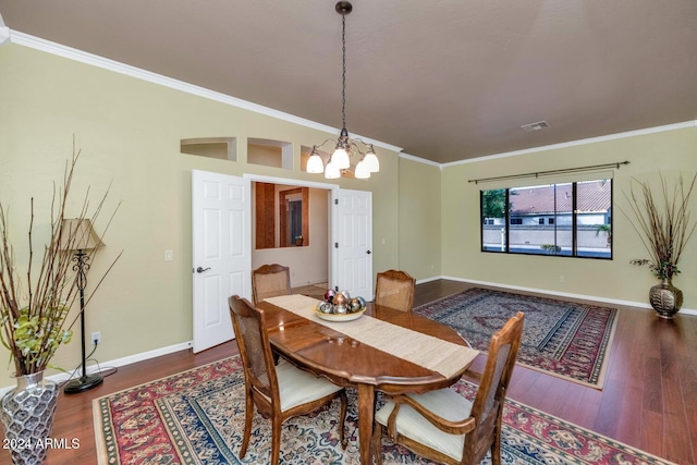 dining space featuring wood-type flooring, ornamental molding, and a notable chandelier