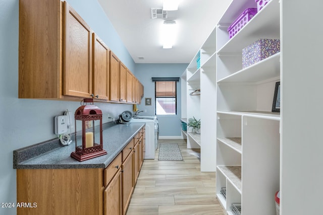 interior space featuring washing machine and dryer and light hardwood / wood-style flooring