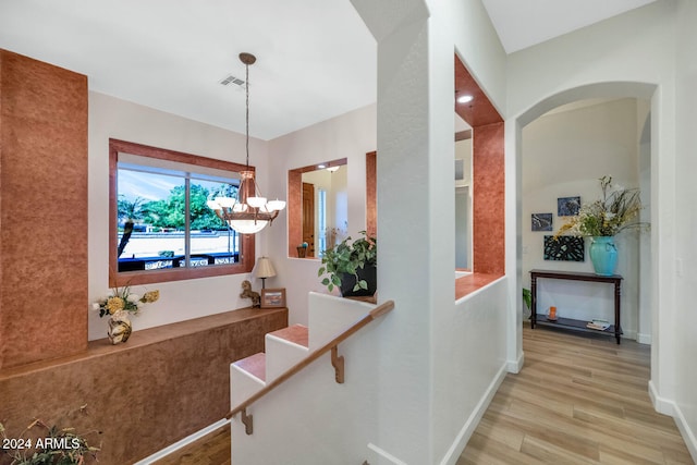 hall featuring light hardwood / wood-style floors and a chandelier