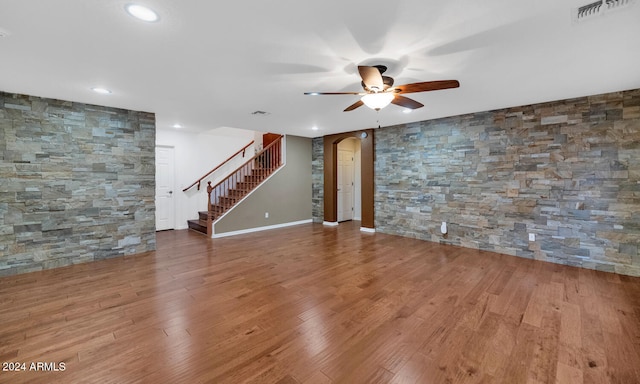 unfurnished living room featuring ceiling fan and hardwood / wood-style floors