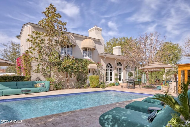 outdoor pool with a patio and an outdoor living space