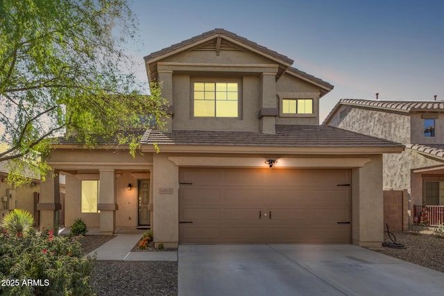 view of front of home with concrete driveway, a tile roof, an attached garage, and stucco siding