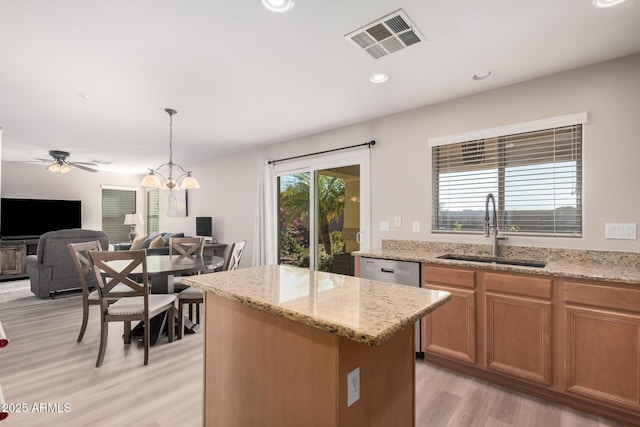 kitchen with a center island, hanging light fixtures, light hardwood / wood-style floors, ceiling fan with notable chandelier, and sink