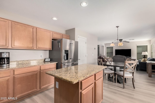 kitchen featuring light hardwood / wood-style floors, light stone counters, ceiling fan with notable chandelier, and high end refrigerator