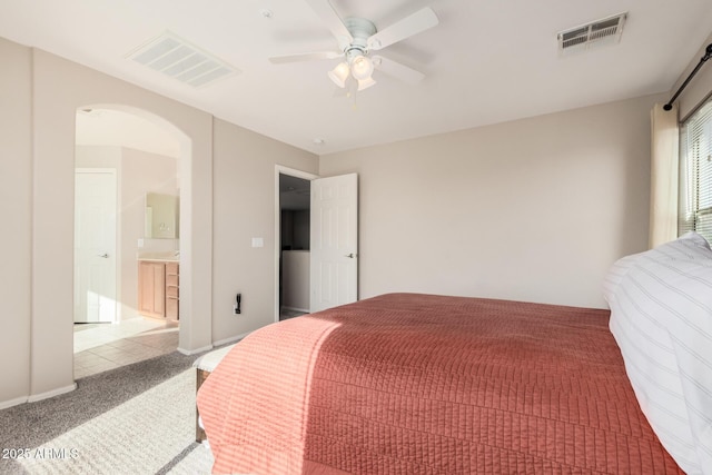 bedroom featuring ensuite bathroom, carpet flooring, and ceiling fan