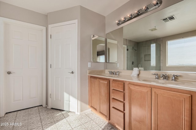 bathroom with tiled shower, vanity, and tile patterned floors