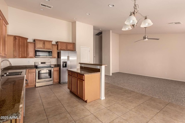 kitchen featuring sink, hanging light fixtures, appliances with stainless steel finishes, and light tile patterned flooring