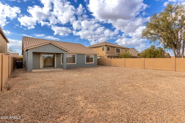 rear view of house with central AC unit and a patio area