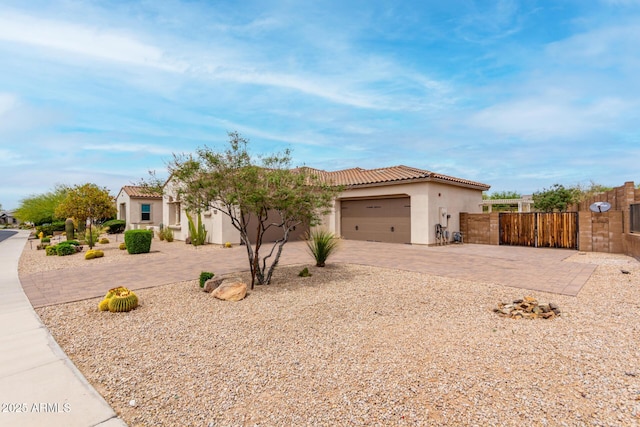 view of front of house featuring stucco siding, driveway, a tiled roof, and a garage