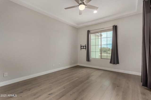 unfurnished room featuring recessed lighting, wood finished floors, a ceiling fan, and baseboards