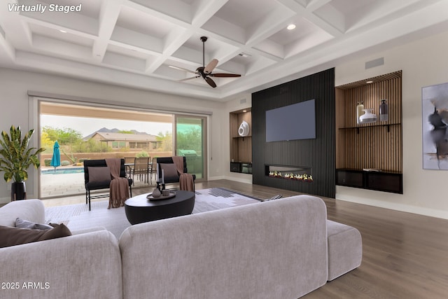living area with ceiling fan, baseboards, coffered ceiling, and wood finished floors