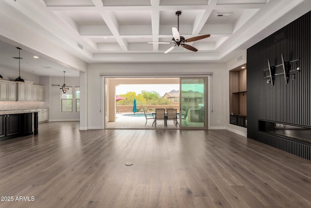 living area with a ceiling fan, wood finished floors, beamed ceiling, baseboards, and visible vents
